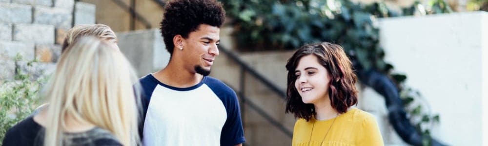 women and man talking outside the building